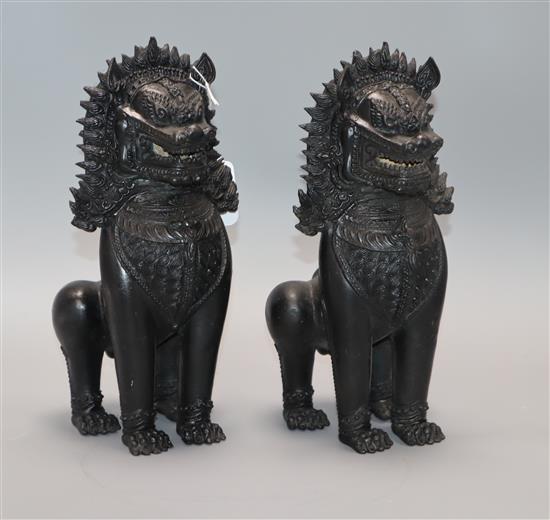 A pair of Thai bronze lion dogs height 27cm approx.